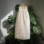 An elegant 2-in-1 heirloom christening outfit for a baby boy in ivory satin, displaying a traditional long gown with pintuck details and the matching short-sleeved romper set.