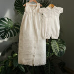 An elegant 2-in-1 heirloom christening outfit for a baby boy in ivory satin, displaying a traditional long gown with pintuck details and the matching short-sleeved romper set.