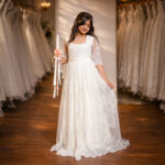 Girl wearing Rosaline premium pearl white Holy Communion gown front view in designer lace net and satin