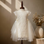 White lace baby girl baptism dress with tulle side panels on mannequin